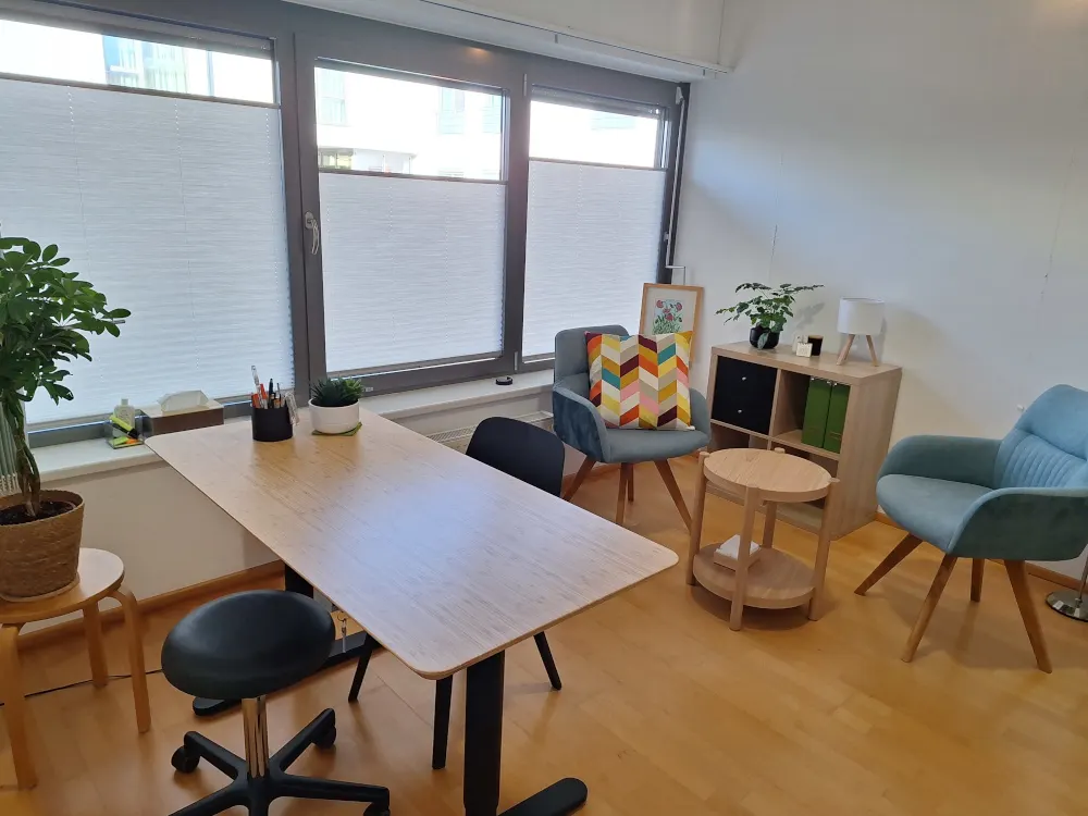 Behandlungsraum mit Therapieliege und Arbeitsbereich